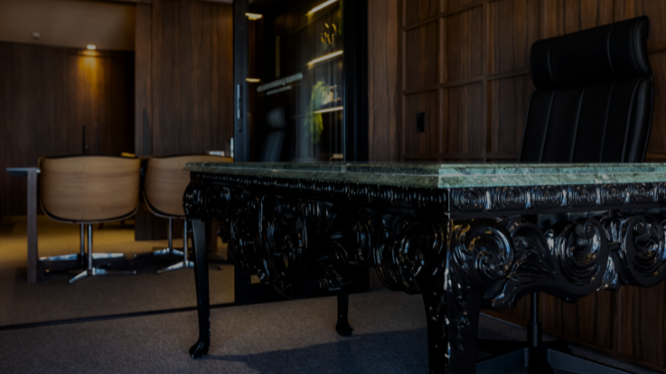 Sala executiva do CR. Andrade & G.J. Sombrio, com mesa clássica de mármore verde e decoração em madeira.